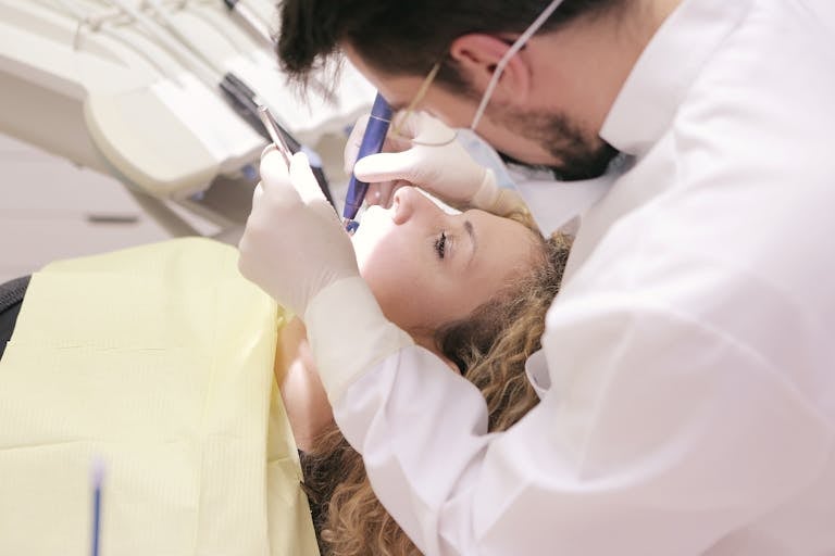 Dentist in clinic providing dental care to patient, focusing on oral health treatment.